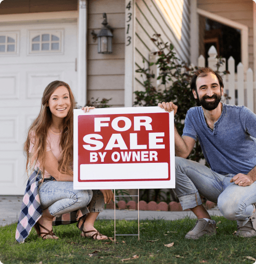 Happy homeowners with a For Sale by Owner sign